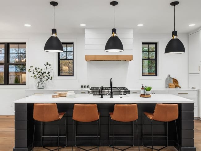 black kitchen island with white countertop and brown hardwood floor from Lonsdale Flooring in Vancouver, BC